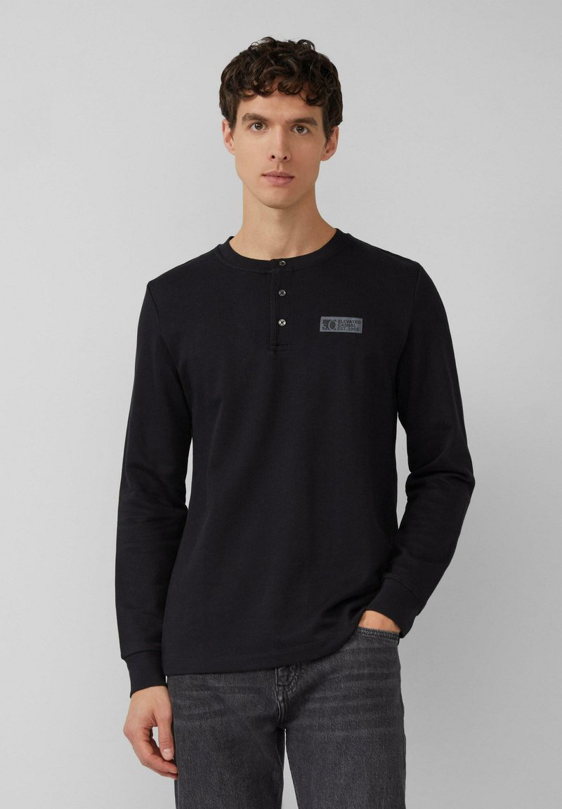 Zwarte lange mouwen henley-shirt met drie knopen bij de kraag, voorzien van een klein logo-opdruk op de linkerbovenborst, gemaakt van zachte stof.
