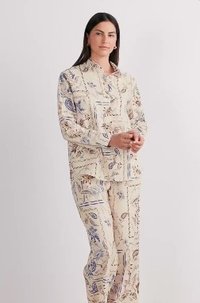 Ensemble de pyjama deux pièces en tissu léger. La chemise a un col et une fermeture à boutons. Fond crème avec des motifs floraux bleus et bruns.