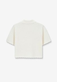 Gehaakt wit kortärmige top met een geschulpte zoom en kraag. Gelaagd stof met een losse pasvorm, ideaal voor layering.