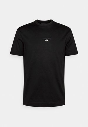 Schwarzes T-Shirt mit kurzen Ärmeln und Rundhalsausschnitt, mit kleinem weißem GA-Logo und geflügeltem Emblem, in der Mitte auf der Brust, vor einfarbigem Hintergrund.