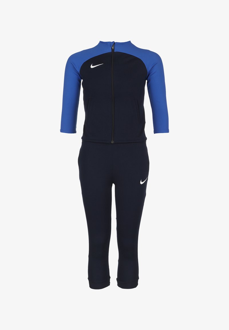 Navy en blauwe sporttracksuit met ritssluiting, driekwartmouwen en een prominente witte Nike-logo. Gemaakt van rekbaar materiaal.