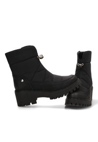 Botas negras hasta el tobillo con tejido acolchado y parte superior sintética. Suela de goma gruesa con patrón de textura. Presenta acentos de hardware plateado.