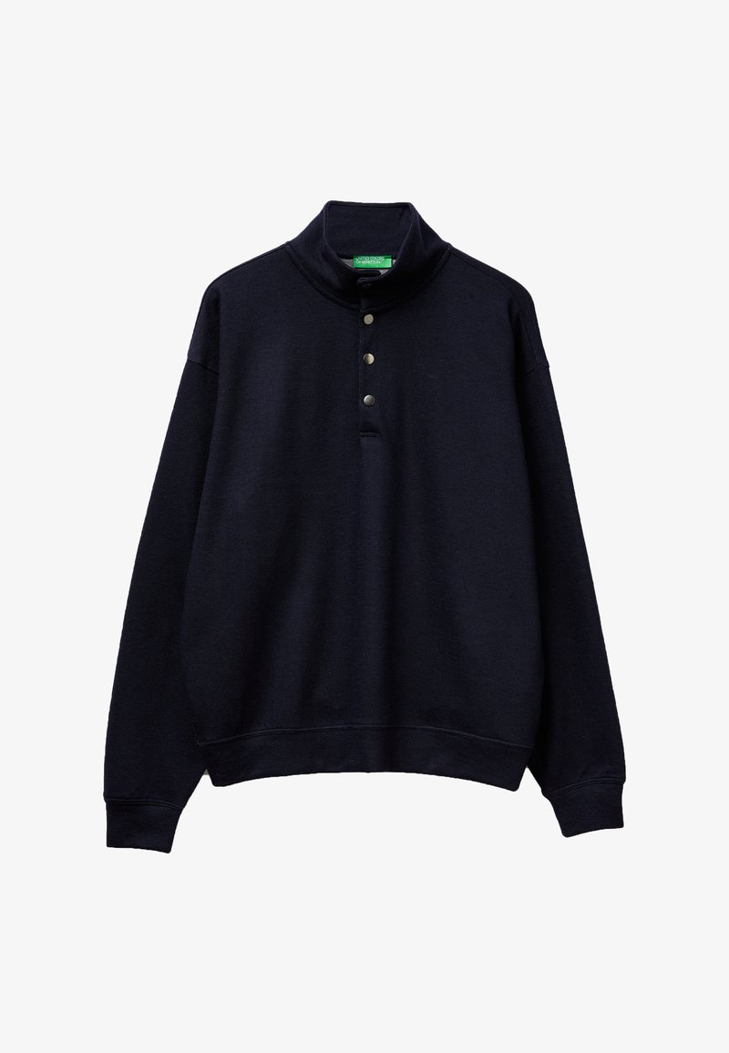 Jersey negro de manga larga con cuello alto y tres botones metálicos a presión en la parte frontal.