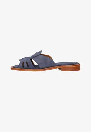 Sandalo a ciabatta in suede blu navy con dettagli di cinturini ritagliati e tacco basso in legno su sfondo bianco.