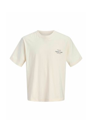 T-shirt beige à manches courtes avec col rond et petit logo texte foncé sur la partie supérieure gauche de la poitrine indiquant "Original Studio."