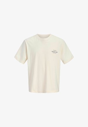 T-shirt beige à manches courtes avec col rond et petit logo texte foncé sur la partie supérieure gauche de la poitrine indiquant "Original Studio."