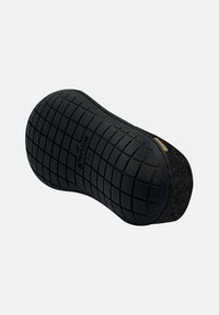 Zwarte rubberen schoenzool met een gestructureerd rasterpatroon, ronde vorm en een bruine viltaccent. Oppervlak lijkt duurzaam en antislip.