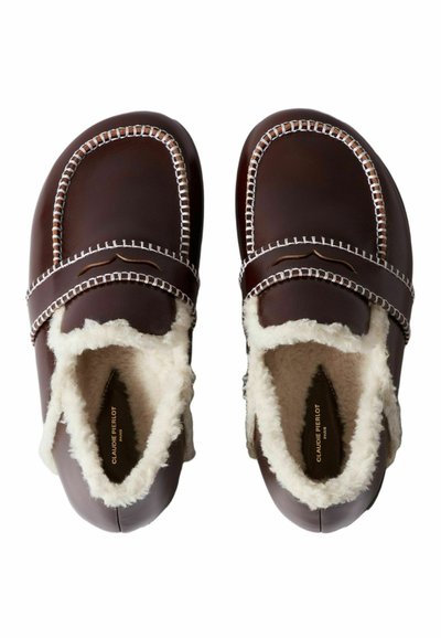 Pantofole in pelle marrone con rivestimento in shearling, caratterizzate da cuciture a contrasto e una forma arrotondata. Design con punta chiusa e dettaglio ricamato.