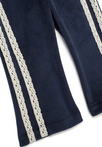 Navy corduroy broek met twee ivoorkleurige kantstrips langs de zijkanten, met een zachte structuur en een uitlopende zoom voor een relaxte pasvorm.