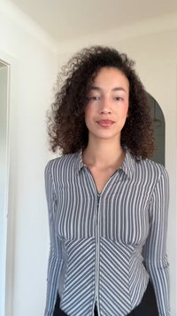 Skjorta med krage och långa ärmar i svartvitt vertikalrandigt mönster med blixtlåsstängning framtill och figursydd design. Mjuk textur.