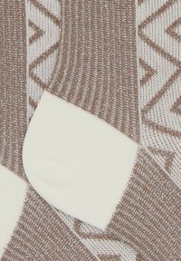 Calze a righe marroni e bianche con un design a coste. La parte superiore presenta un motivo geometrico, mentre la punta è di un bianco solido.
