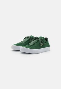Sapatilhas em malha verde com um upper texturizado, sola de borracha branca e atacadores tonais. Apresenta um pequeno detalhe de logo na lateral.