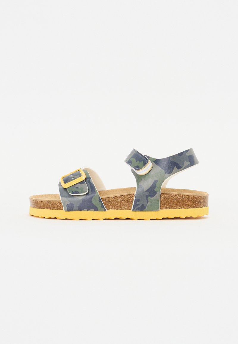 Camo-pattern sandals with adjustable straps, cork footbed, and textured yellow rubber sole. Features a double buckle design.