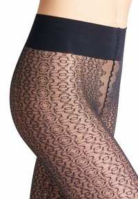 Collant neri a fantasia con un design trasparente e testurizzato e una vita nera solida. Presenta intricati motivi floreali su tutta la superficie.