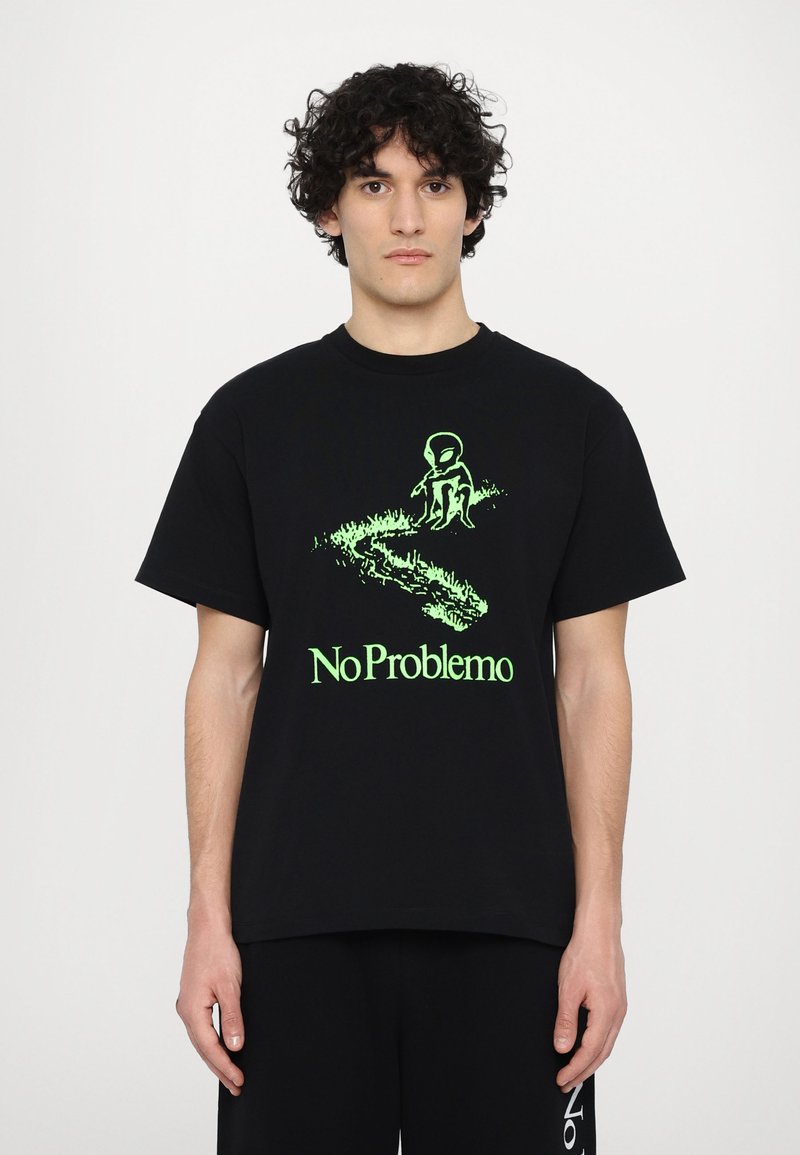 Sort bomulds T-shirt med et strålende grønt alienmotiv og teksten "No Problemo" med græsdetalje, rund halsudskæring og korte ærmer.