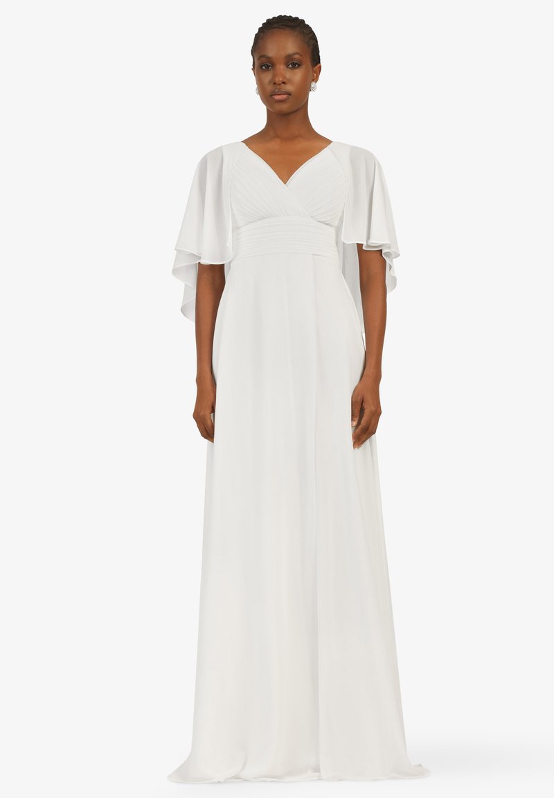 Weißes Kleid mit schwingenden Ärmeln, V-Ausschnitt, gerafftem Oberteil und fließendem Rock, aus leichtem Stoff gefertigt. Glatte Textur, elegantes Design.