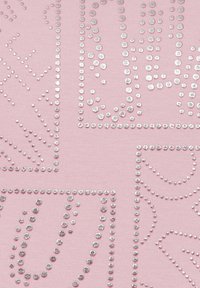Roze stof met zilveren studs die in verschillende geometrische patronen zijn gerangschikt, wat een gestructureerd oppervlak met een glanzend, decoratief effect creëert.