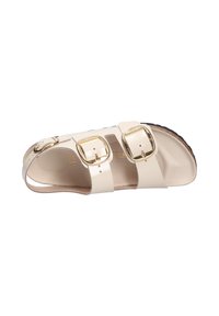 Sandalo beige a due cinturini con due chiusure ad occhio in tono oro. Realizzato in materiale sintetico liscio, con una soletta testurizzata e una suola nera.