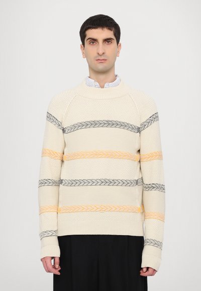 Pull en tricot crème avec des rayures horizontales noires et orange, comportant un col côtelé et des motifs texturés sur le corps et les manches.