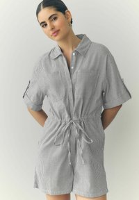 Gestreepte playsuit in grijs en wit, met een gekraagde halslijn, korte mouwen, een koordjes taille en voorkruimelzakken. Soepele textuur.
