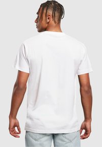 Hvid bomulds t-shirt med korte ærmer, rund halsudskæring og en afslappet pasform. Har en glat tekstur og et enkelt design uden dekorationer.