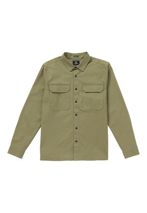 Chemise à manches longues vert olive en tissu coton avec fermeture à boutons, deux poches poitrine et boutons noirs. Elle présente un col classique et un détail de logo.
