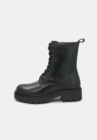 Stivaletto in pelle nera con punta arrotondata, chiusura con lacci e suola spessa. Presenta un pratico cordino sul retro e una texture liscia.