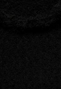 Tissu noir texturé avec une surface duveteuse, présentant une zone de col tissée de manière lâche et une apparence douce et mate.