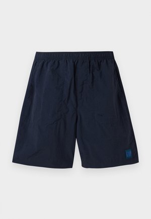 Marineblå shorts laget av lett materiale med elastisk midjebånd og en liten firkantet GAP-logo nederst til høyre.