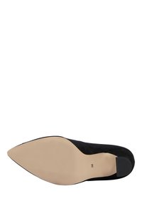Scarpa da donna in camoscio nero con punta a punta, mostrata dal fondo con la taglia 38 contrassegnata vicino al tallone.