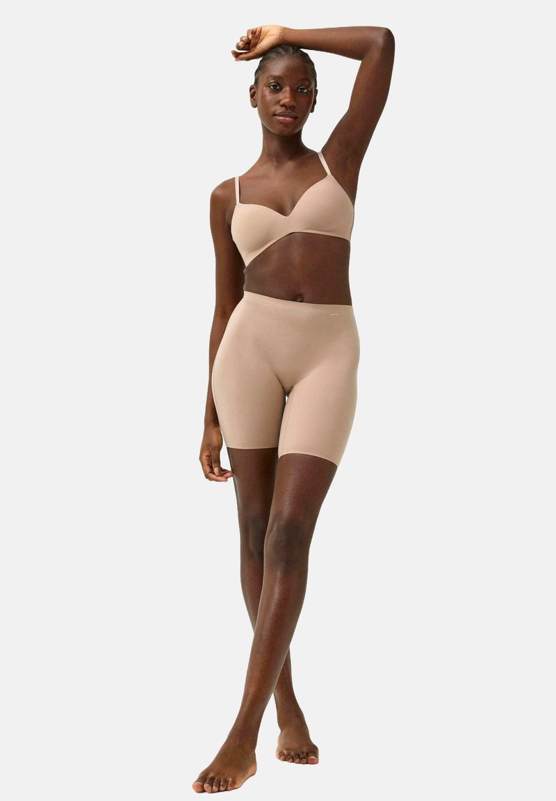 Naadloze nude bh en hooggeknipte shorts van zachte, rekbare stof. De bh heeft slanke bandjes en een glad ontwerp.