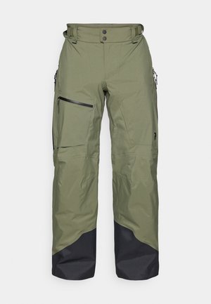 Olive green waterproof pants with a black lower section, featuring zippered pockets and a waistband with two buttons and belt loops.