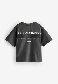 Melnas kokvilnas krekls ar īsām piedurknēm, aizmugurē ar baltu tekstu, kas ietver "ALL SAINTS" un "LONDON", ar brīvu piegriezumu.