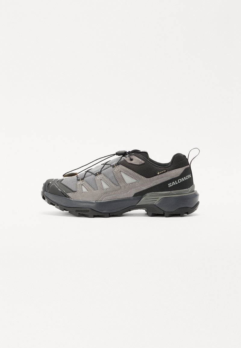 Szare buty outdoorowe z siateczkową cholewką, gumową podeszwą i solidnym systemem sznurowania. Posiadają wzmocniony czubek oraz logo marki na pięcie.