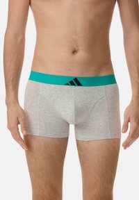 Boxer-briefs gris avec une ceinture teal arborant un logo noir. Le tissu semble lisse avec un ajustement serré et des coutures plates.
