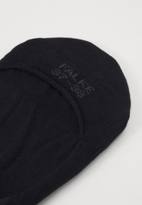 Chaussette noire en coton à cheville avec une texture douce et un design arrondi, ornée d'un logo discret imprimé sur le dessus.