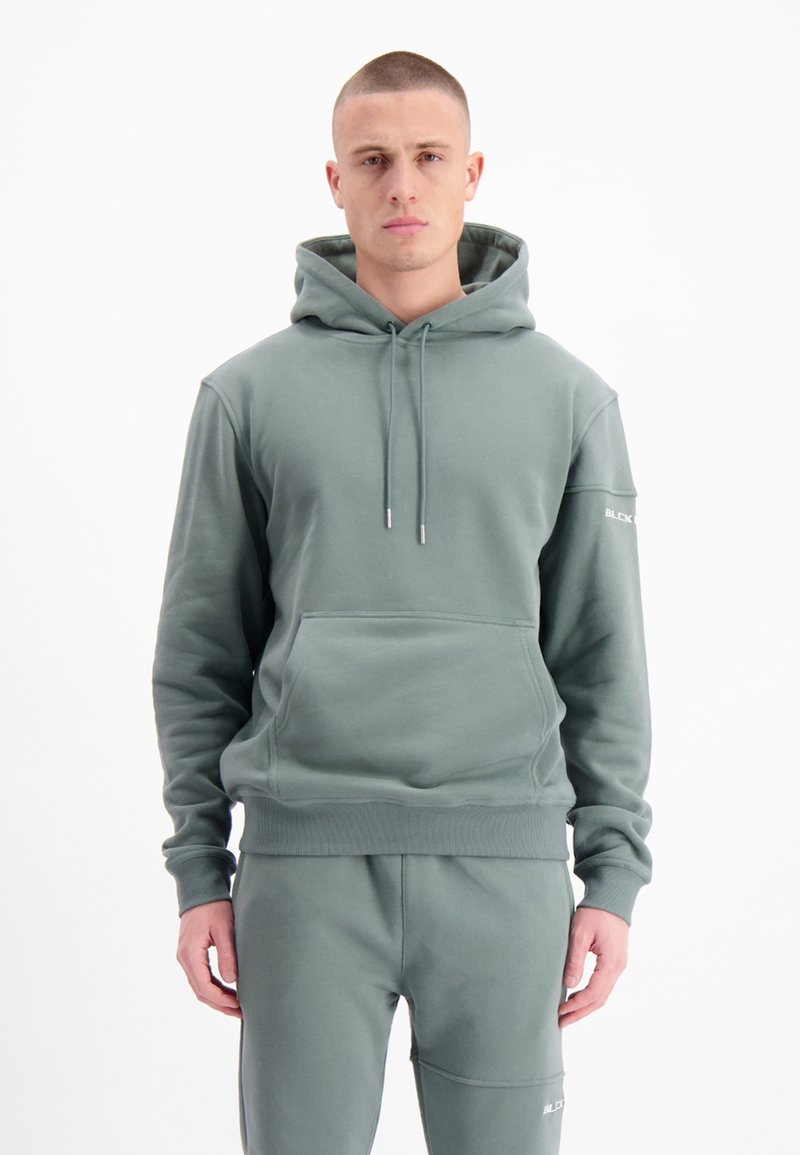Olijfgroene hoodie gemaakt van zachte stof, met een voorzak, verstelbare trekkoorden in de capuchon, ribgebreide manchetten en een logo op de mouw.