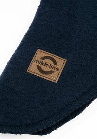 Tmavě modrý plstěný výrobek s hnědou koženou nášivkou s logem "mikk-line", prošitými okraji a hladkou texturou.