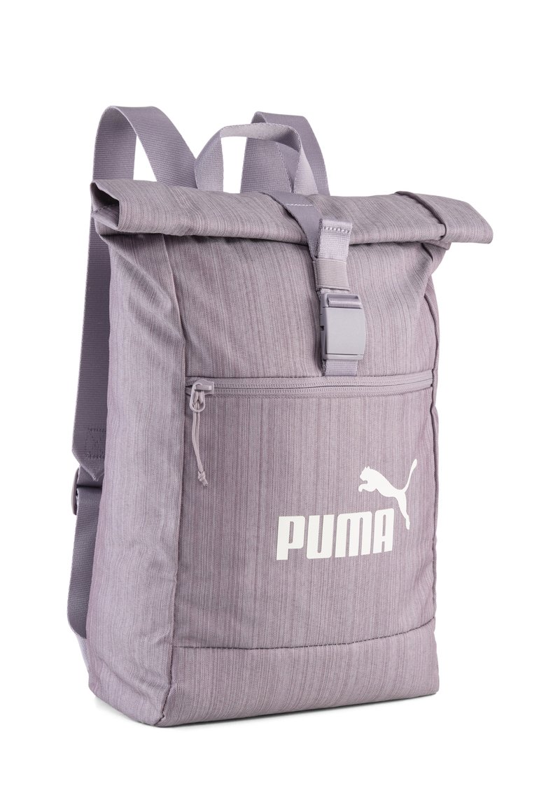 Sac à dos violet à rabat, fabriqué en tissu texturé, avec une poche zippée à l'avant et un logo Puma blanc. Sangles réglables et fermeture à boucle.