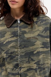 Camo-gepatroneerde jas van denim met een bruine ribfluwelen kraag. Heeft een rits aan de voorkant en een geborduurd "BDG Jeans" logo.