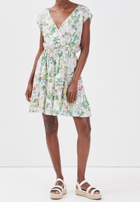 Sukienka w kwiatowy wzór z dekoltem w serek, krótkimi rękawkami i elastyczną talią. Tkanina jest lekka, z zielonymi i wielokolorowymi kwiatowymi motywami.