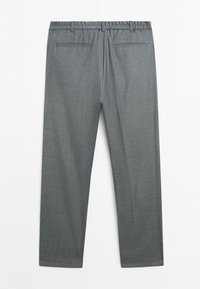 Szare formalne spodnie z elastyczną talią, szlufkami na pasek i dwoma tylnymi kieszeniami z rozcięciami, rozłożone na płasko na białym tle.