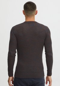 Dark ribbed knit sweater featuring a crew neckline, long sleeves, and a textured fabric woven in blue and brown tones.