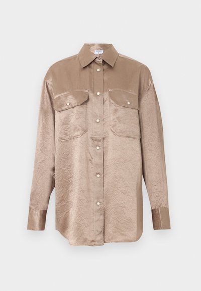 Μπεζ σατινέ πουκάμισο με μακριά μανίκια, εμπρός με κουμπιά, δύο τσεπάκια στο στήθος με καπάκια και κουμπιά και κλασικό γιακά.