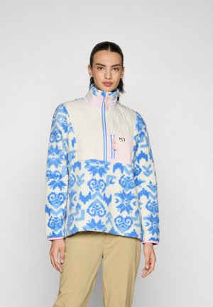 Fleece-Pullover mit einem gesteppte cremefarbenen Oberteil, blauen Blumenmustern und einem rosa Reißverschluss. Verfügt über eine Brusttasche und einen hohen Kragen.