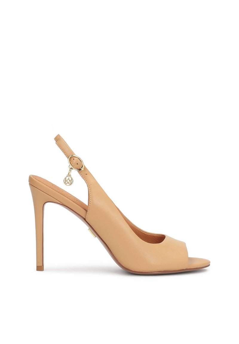 Smėlio spalvos odiniai slingback lygios išvaizdos bateliai su atvira nosimi, plonu aukštu kulnu ir apvali aukso detalė ant dirželio. Vienoda lygi tekstūra.