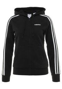 Sudadera negra de mezcla de algodón, con cremallera frontal, dos bolsillos y rayas blancas en las mangas. Logo de Adidas en el pecho.