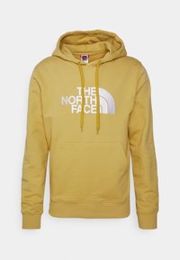 Hoodie amarelo com bolso canguru, punhos e bainha canelados. Apresenta um grande logótipo branco com um design curvado na frente.