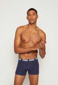 Navy blue boxer briefs with a white "PUMA" logo on the elastic waistband. Made from smooth, stretchable fabric for comfort.