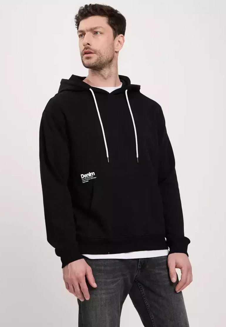 Czarna bluza z kapturem z białymi sznurkami, kieszenią kangurką i małym logo z przodu. Teksturowana tkanina, luźny krój i ściągacze w mankietach.